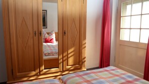 A bedroom with two beds, a wooden wardrobe, and a window with curtains. - Apartment No. 2, Jenner, for 1 to 2 people, 40 sqm, 1 bedroom, balcony (Schönau am Königssee)