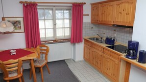 A compact kitchen with wooden cabinets, a sink, and a coffee maker. - Apartment No. 2, Jenner, for 1 to 2 people, 40 sqm, 1 bedroom, balcony (Schönau am Königssee)