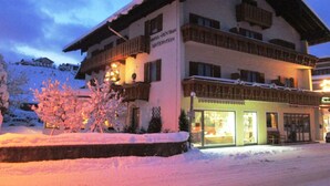 A multi-story hotel with a snow-covered exterior and balconies. - Apartment for 1-2 people, separate bedroom, shower / toilet, balcony, 40 sqm (Schönau am Königssee)