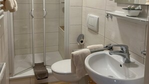 A bathroom with a shower, toilet, sink, and mirror. - Apartment for 1-2 people, separate bedroom, shower / toilet, balcony, 40 sqm (Schönau am Königssee)