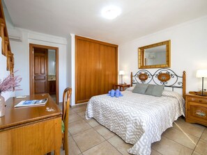 A bedroom with a bed, bedside tables, a wooden wardrobe, a desk, and a chair. - Wonderful private villa for 11 guests with WIFI, A/C, private pool, TV, patio and pets allowed (Calpe)