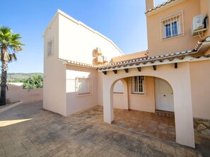 A two-story building with a tiled roof, a covered patio area with arches, and a palm tree in the background. - Wonderful private villa for 11 guests with WIFI, A/C, private pool, TV, patio and pets allowed (Calpe)