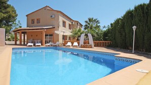 A swimming pool with lounge chairs and umbrellas, surrounded by a house and trees. - Wonderful private villa for 11 people with WIFI, private pool, A/C, TV, terrace and pets allowed (Benissa)