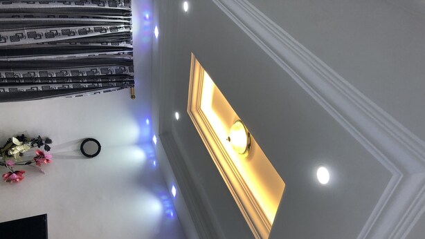 Techo con iluminación empotrada y una lámpara fijada a la pared.
