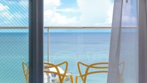 Un balcón con sillas amarillas y vista al mar.