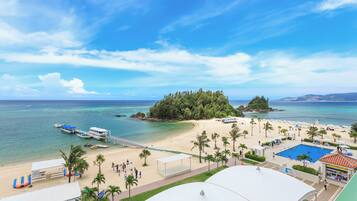 Enjoy stunning ocean views from this beachfront hotel, featuring a large pool, beach umbrellas, and a covered seating area.
