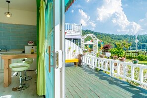 A wooden deck with a white railing, a bench, and potted plants. - Goseong Sunshine Home Pension (Goseong)