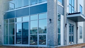 A modern multi-story building with large glass windows and a brick facade.