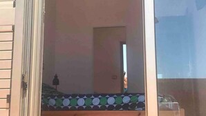 Une pièce comprenant un lit, une petite table et une porte donnant sur une autre pièce.