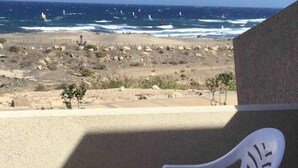 Un balcon avec vue sur l’océan et la plage.