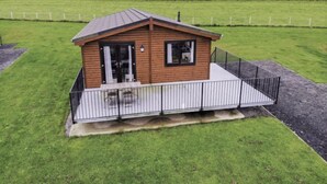 Eine kleine Holzhütte mit einem umzäunten Patio.