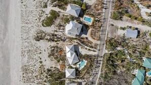 An aerial view of a coastal property with multiple buildings, a swimming pool, and a road. - The Bungalow - Captiva Beach Cottage on Turner Beach (Captiva)
