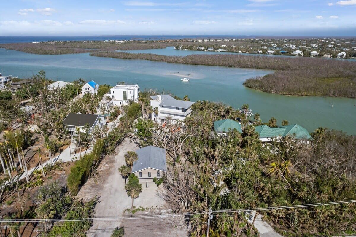 Zona residencial costera con casas, un puerto deportivo y vista al océano.