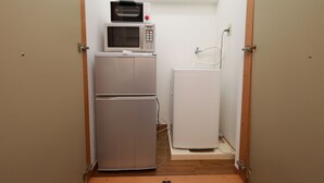 A compact kitchenette with a microwave and a refrigerator. - IBASHO Shibuya Higashi 604 (Tokyo)