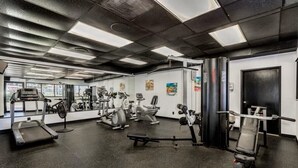 Uma academia com diversos equipamentos de exercício, incluindo esteiras, bicicletas ergométricas e aparelhos de musculação.
