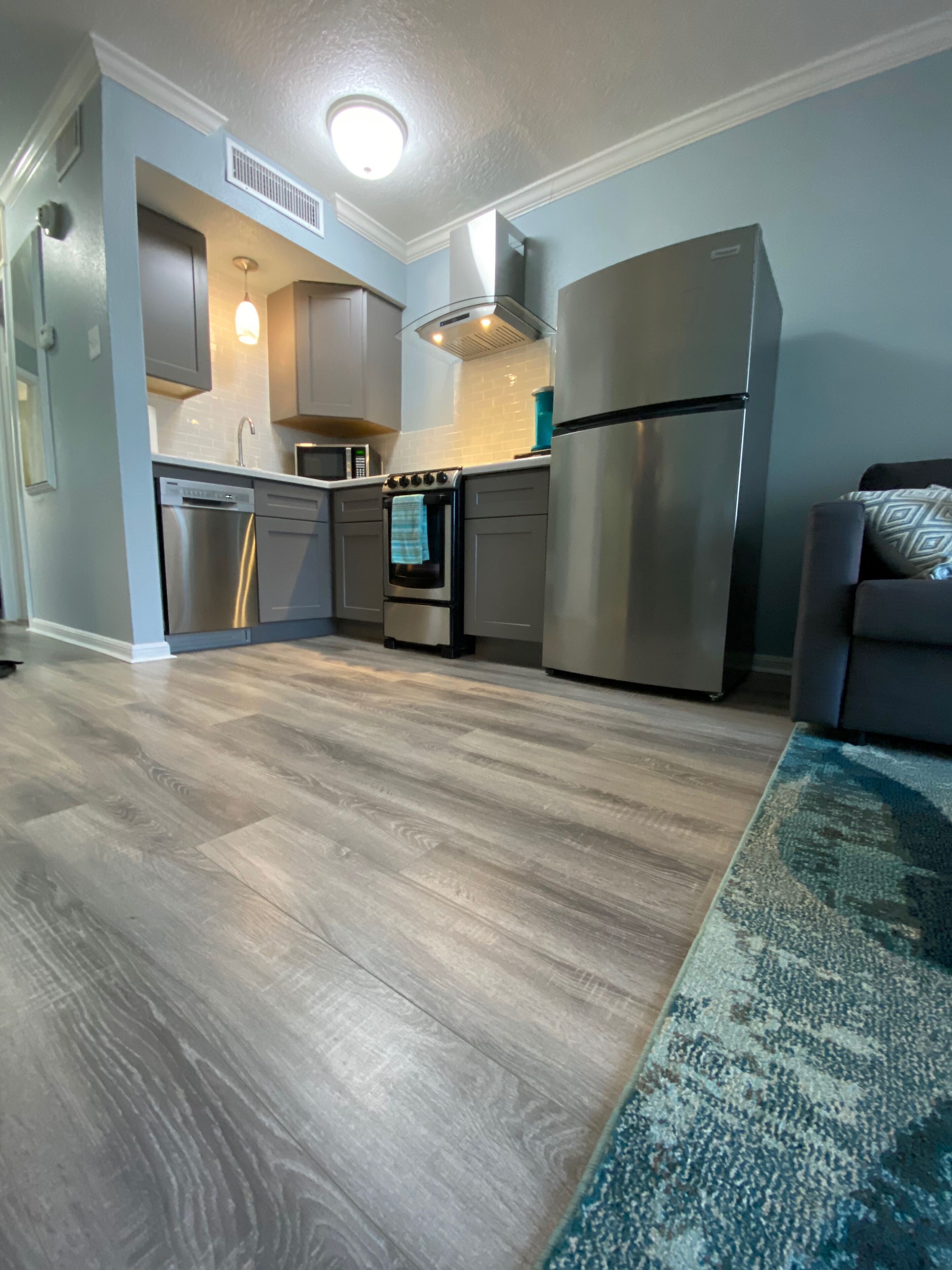 A modern kitchen with stainless steel appliances, a dishwasher, and a microwave.
