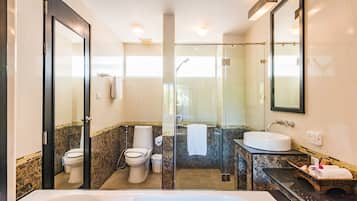 Un baño moderno con ducha de vidrio, una bañera grande y un tocador con azulejos de mármol.