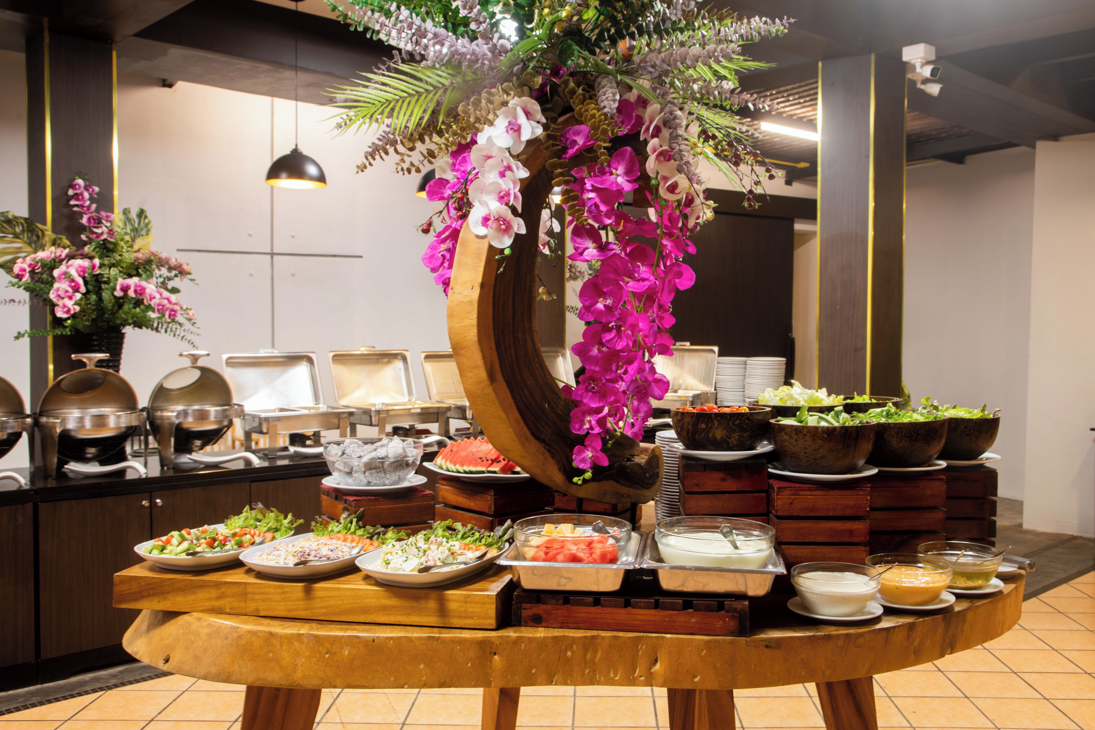 Ein reichhaltiges Buffet mit verschiedenen Speisen und einer dekorativen Blumenanordnung.