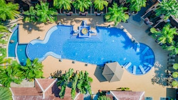 Relax by the pool surrounded by lush greenery and lounge under shaded areas.