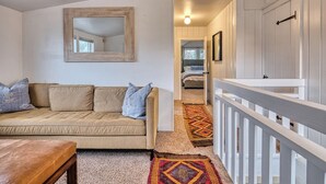 A living room with a beige sofa, a wooden bench, and a patterned rug. - 5 Bedroom, 3 Bath House! With Brand New Hot Tub! (Eugene)