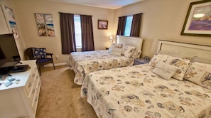 A hotel room with two beds, a desk, a chair, and artwork on the walls. - The Palms * Luxury 3BR Condo End-Unit Home (Rehoboth Beach)