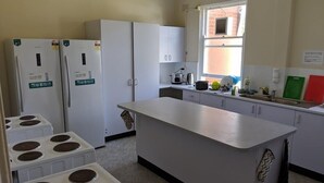Una cocina con armarios blancos, una isla central y un ventanal.