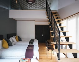 Un dormitorio con una cama grande, un escritorio y una escalera.