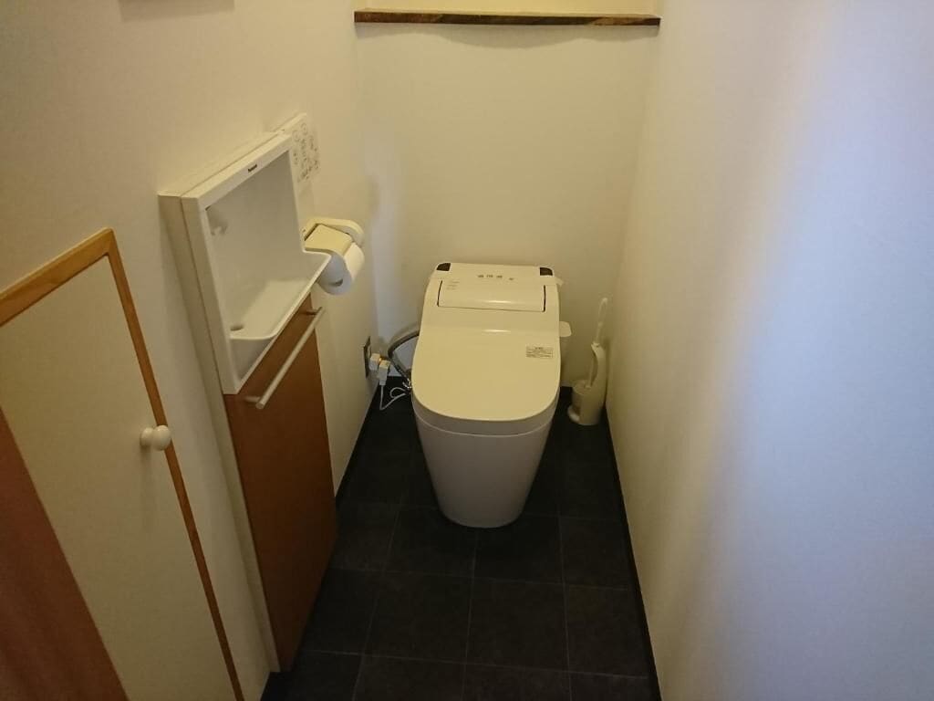 A small bathroom with a toilet, a sink, and a mirror.