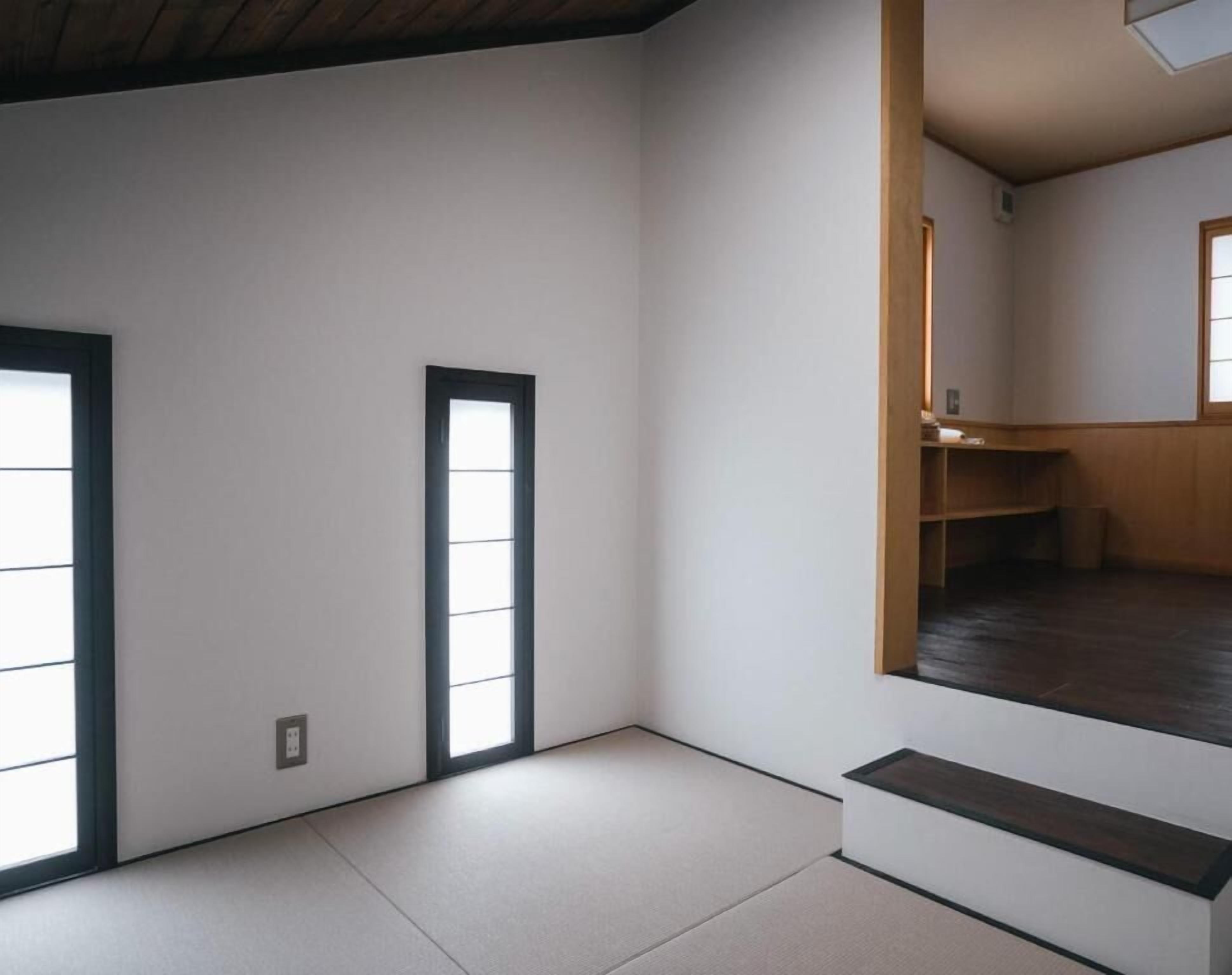 A room with tatami flooring, a sliding door, and a small wooden shelf.