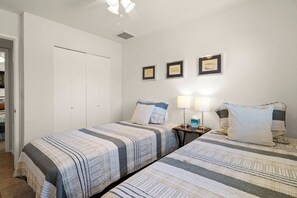 A bedroom with two beds, a nightstand, a lamp, and three framed pictures on the wall. - Rustic Cottage Feel, Close to Wineries, Sleeps 6! (Cornville)