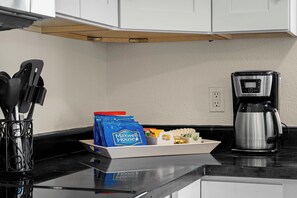 A kitchen with a coffee maker, a knife holder, and a tray with food items and a Maxwell House coffee bag. - Rustic Cottage Feel, Close to Wineries, Sleeps 6! (Cornville)