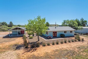 A two-story house with a covered porch and a small attached garage. - Rustic Cottage Feel, Close to Wineries, Sleeps 6! (Cornville)