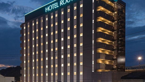 Ein mehrstöckiges Hotel mit einem gut sichtbaren Schild, auf dem "HOTEL ROUTE INN" steht.