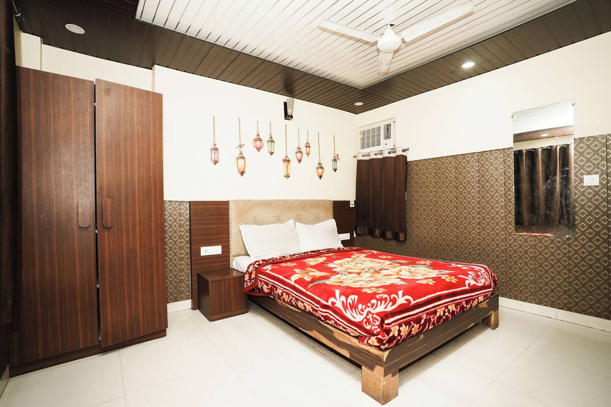 A bedroom with a bed, wardrobe, and a ceiling fan.