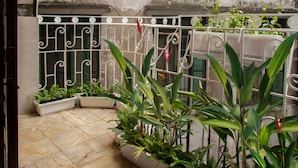 A courtyard with tiled flooring, potted plants, and decorative metal railings. - Centraltique Hidden Oasis (Hanoi)