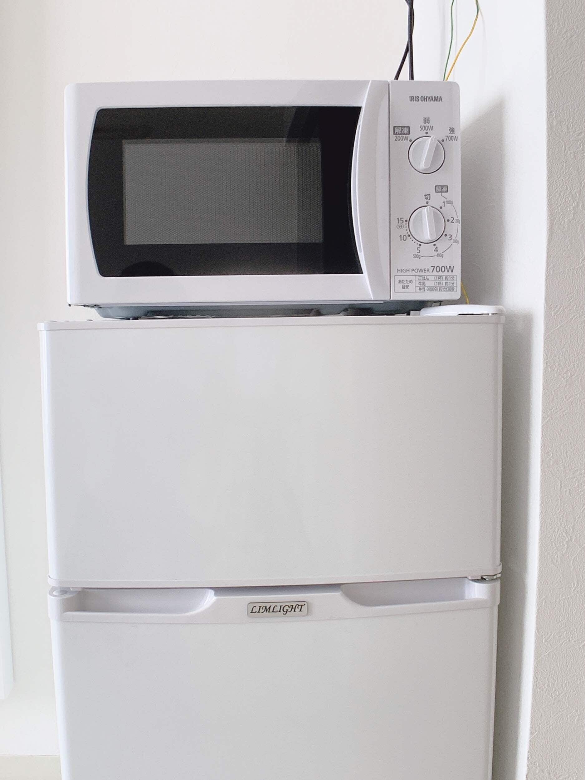 Un refrigerador blanco con microondas incorporado arriba.
