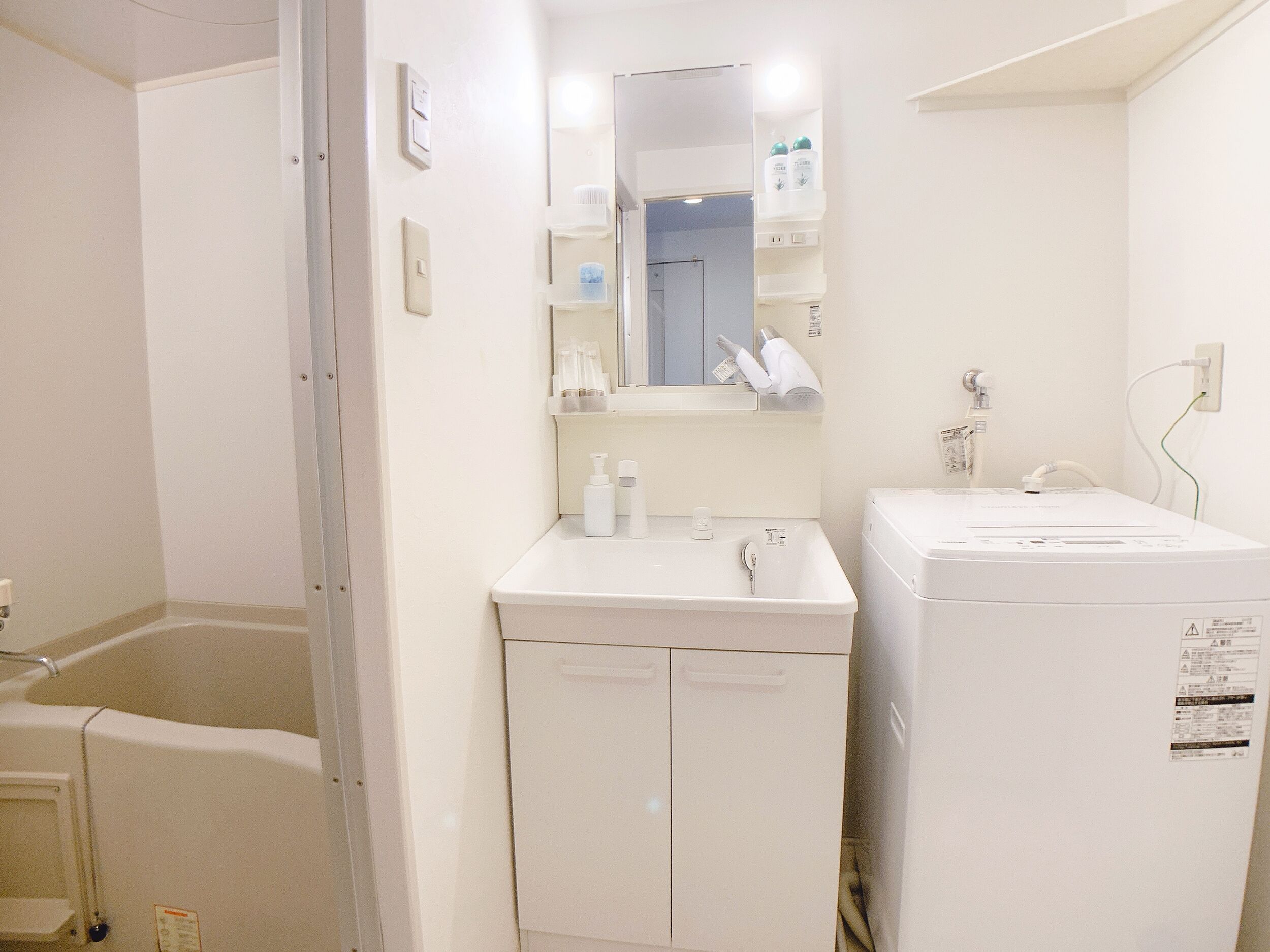 A small, clean bathroom with a white sink, mirror, and a white cabinet.