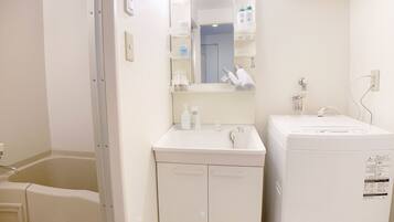 A small, clean bathroom with a white sink, mirror, and a white cabinet.