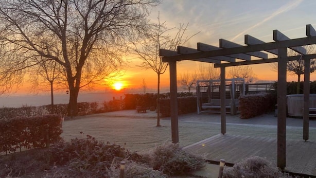 En pavillon med udsigt til en solnedgang over en park.
