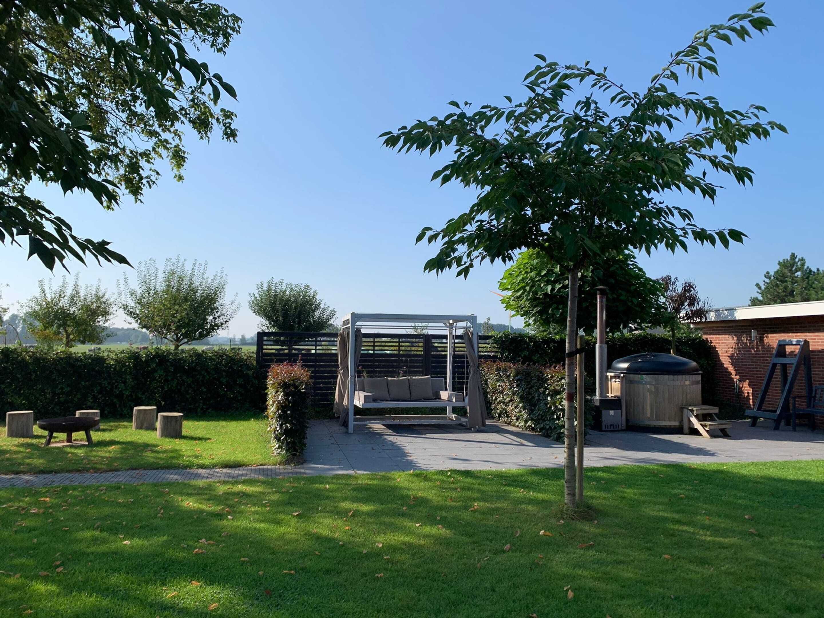 A backyard with a pergola, seating area, and a barbecue grill.