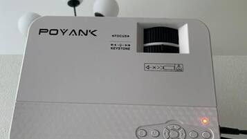 Dispositivo electrónico blanco con el nombre de marca 'POYAN' y modelo 'FOCUS' a la vista. Tiene un botón de encendido, una luz indicadora roja y un símbolo de batería.