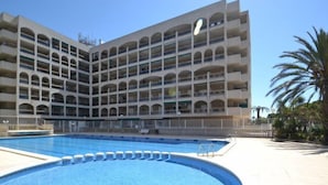 A multi-story hotel with a large swimming pool in the foreground. - Turquesa by Interhome (La Pineda)