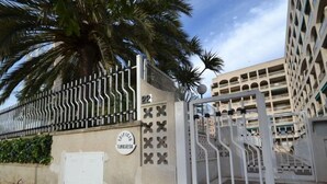 A gated entrance with a sign reading "Edificio Turquesa" and a building with a modern architectural style in the background. - Turquesa by Interhome (La Pineda)