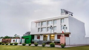 A modern building with a flat roof, multiple windows, and a flagpole. - Gulabi Bagh Resort (A unit of Sarvmangla Garden) (Jaipur)