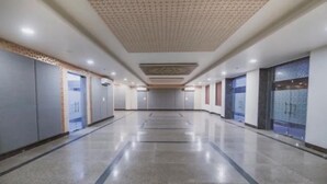 A hotel corridor with a patterned ceiling, doors on both sides, and a shiny floor. - Gulabi Bagh Resort (A unit of Sarvmangla Garden) (Jaipur)