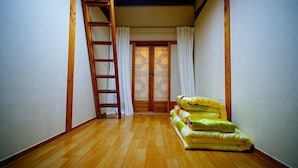A narrow hallway with wooden flooring, a wooden ladder, and a set of sliding doors with a traditional design. - Jeonju Happy Maru Hanok (Jeonju)