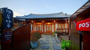 A traditional Japanese building with a tiled roof and wooden doors. - Jeonju Happy Maru Hanok (Jeonju)