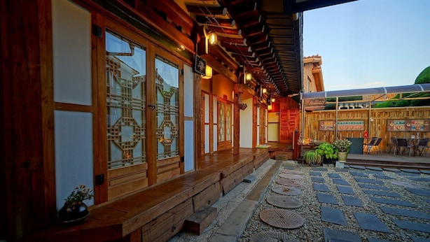 A traditional wooden building with large sliding doors and a covered outdoor seating area. - Jeonju Happy Maru Hanok (Jeonju)