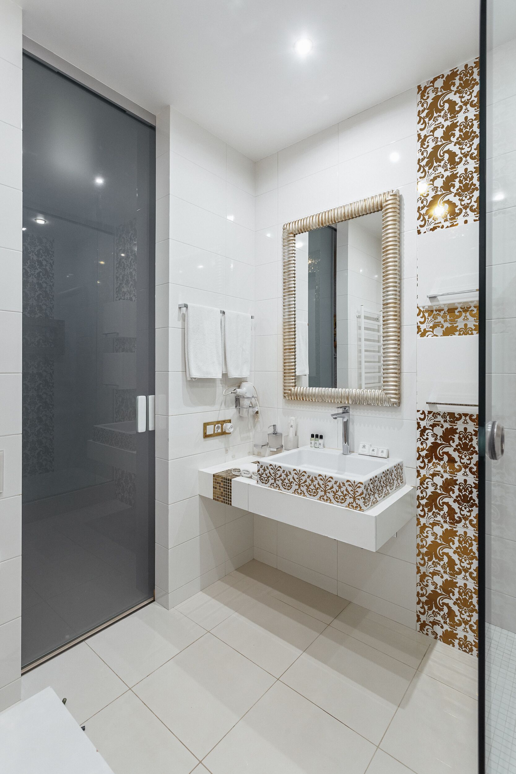 A modern bathroom with a glass shower enclosure, a large mirror, and a vanity with two sinks.