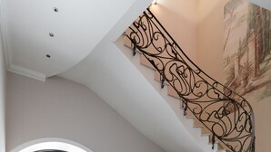 A grand staircase with ornate metal railings leading to a landing. - Royal Apartment Uspenskaya 12 (Odesa)